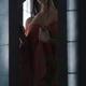 Sensual portrait of an Asian woman in undone red kimono standing by an... (thumbnail)