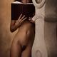Nude woman with a book leaning against an antique clock in old house s... (thumbnail)