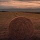Straw bale in a dramatic countryside sunset scenery of farm field in I... (thumbnail)