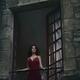 Woman in red dress standing in an open window in a French stone house... (thumbnail)