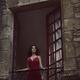 Beautiful woman in red dress standing in open window of medieval Frenc... (thumbnail)