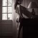 Woman standing naked on tip toes by a wall with her back with an innoc... (thumbnail)