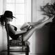 Woman with sexy legs in fashion swimsuit and elegant hat reading in a... (thumbnail)