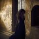 Woman in long dress walking along a shabby dark old street of European... (thumbnail)