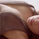 Woman lying in bed with her dress open on her chest Sensual closeup of... (thumbnail)