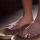 Closeup of a woman with bare feet standing on Yogic Sadhu Board board... (thumbnail)
