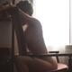 Artistic nude portrait of a beautiful woman sitting naked facing armch... (thumbnail)