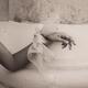 Abstract gentle female hand with a silk bow leaning against rustic old... (thumbnail)