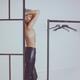Fashion studio portrait of a half naked woman in a fitting room wearin... (thumbnail)