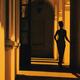 Mysterious dark silhouette of a woman walking in a shadowy arched hall... (thumbnail)