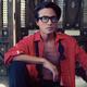 Portrait of a man in an undone stylish red shirt and glasses sitting r... (thumbnail)