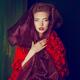 High fashion portrait of a red-haired woman wearing a purple shawl aro... (thumbnail)