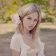 Romantic portrait of a young pretty woman with a pink flower in her bl... (thumbnail)