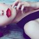 Closeup of a beautiful woman sensual face with bright red lipstick lyi... (thumbnail)