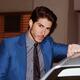 Handsome man in elegant blue suit leaning against a car... (thumbnail)