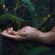 Beautiful nude woman lying relaxed on a mossy tree in green forest wit... (thumbnail)