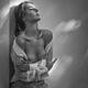 Sensual portrait of a woman standing topless leaning against a wall in... (thumbnail)