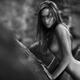 Beautiful nude woman with wild wolf eyes look leaning against a rock i... (thumbnail)