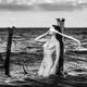 Woman standing naked in water against a rusty post with a blindfold Fi... (thumbnail)