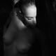 Beautiful woman standing with her naked body covered by the shadows li... (thumbnail)