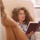 Young carefree woman in glasses and tiny shorts with sexy long legs re... (thumbnail)