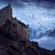 Flock of crows over a French stone castle on a mountain cliff under dr... (thumbnail)