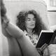 Young woman in glasses and tiny shorts with sexy long legs reading a b... (thumbnail)