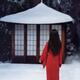 Asian woman in red kimono standing in white snow looking at a little t... (thumbnail)