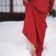 Woman in red kimono walking barefoot in deep white snow towards traditional Japanese house