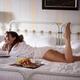 Woman lying on a bed in underwear with a book and a plate with coffee... (thumbnail)