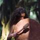 Young woman with a shamanic drum in a tranquil forest scenery... (thumbnail)