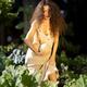 Sexy young woman with two ripe melons in a garden in a revealing overa... (thumbnail)