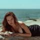 Sensual portrait of a young woman in black dress posing on a driftwood... (thumbnail)