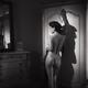 Sexy French woman standing naked leaning against an antique wardrobe r... (thumbnail)