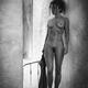 Beautiful young woman standing naked thoughtfully leaning against a wa... (thumbnail)