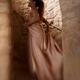 Woman in long dress running up the stairs of a spiral staircase in a d... (thumbnail)