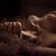 Sensual closeup portrait of a woman lying naked in bed with her hand o... (thumbnail)