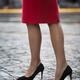 Closeup of sexy woman legs in high heel shoes and red dress walking on... (thumbnail)
