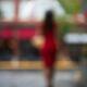 Woman in red dress with umbrella walking away in the rain Abstract out... (thumbnail)