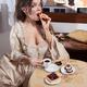 Woman in vintage Italian carnival dress eating tart pastry at café ta... (thumbnail)