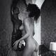 Beautiful sexy woman standing naked leaning with her bare breasts agai... (thumbnail)
