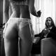 Back of a woman in sexy white lingerie approaching a man in a chair wi... (thumbnail)