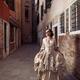 Beautiful Venetian lady in vintage dress and carnival mask walking alo... (thumbnail)