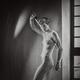 Expressive portrait of a half nude woman with short hair holding a fen... (thumbnail)