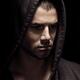 Dramatic portrait of man in black hoodie with serious thoughtful expre... (thumbnail)