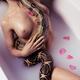 Beautiful sexy woman in a milk bath with a large boa snake wrapped aro... (thumbnail)