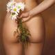Girl with white daisies behind her naked back. Closeup of lady buttock... (thumbnail)