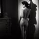 Woman posing nude leaning against an antique wardrobe revealing her be... (thumbnail)