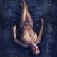 Beautiful nude woman lying in dark water relaxed with closed eyes view... (thumbnail)