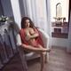 Beautiful woman sitting naked in a chair with seductive look and cross... (thumbnail)